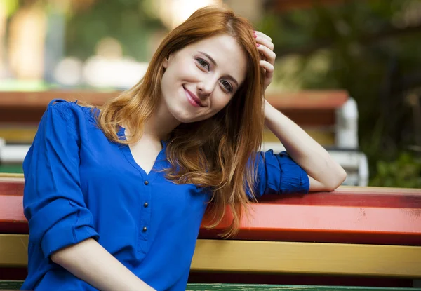 Stile rossa ragazza seduta sulla panchina nel caffè — Foto Stock