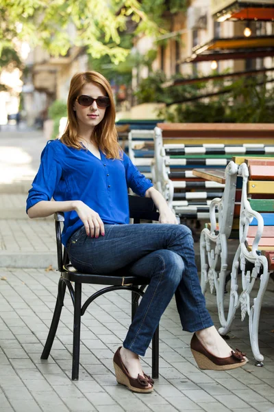 Stile rossa ragazza si siede sulla sedia nel caffè — Foto Stock