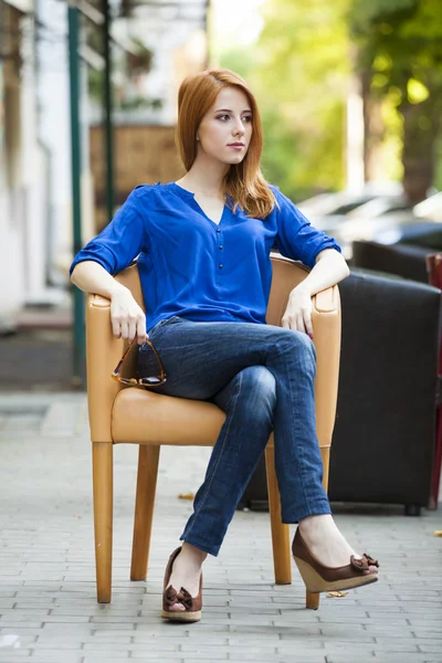 Estilo pelirroja chica sittin en la silla en el café —  Fotos de Stock