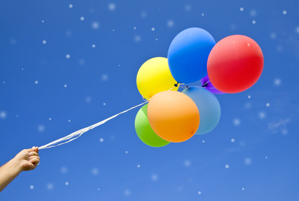 Female holding multicolored balloons