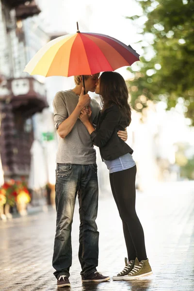 Junges Paar auf der Straße der Stadt mit Regenschirm — Stockfoto