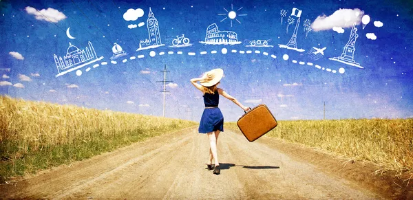 Chica solitaria con maleta en el camino del campo soñando con viajar . Imágenes de stock libres de derechos