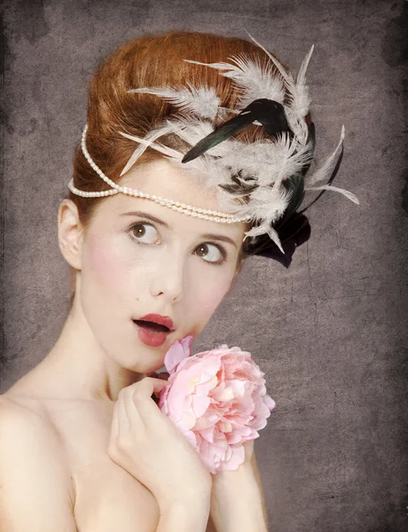 Здивована руда дівчина з стилем волосся рококо та квіткою у вині — стокове фото