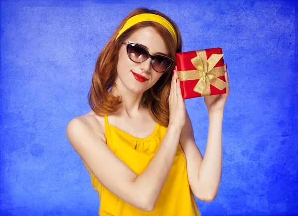 Amerikanische rothaarige Mädchen in Sonnenbrille mit Geschenk. — Stockfoto