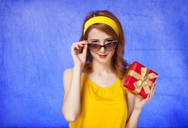 Αμερικανική κοκκινομάλλα κορίτσι σε γυαλιά ηλίου με δώρο. — Φωτογραφία Αρχείου
