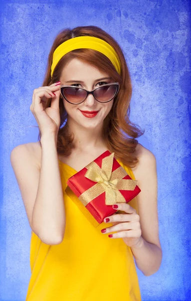 Americká rusovláska dívka v sluneční brýle s dárkem. — Stock fotografie