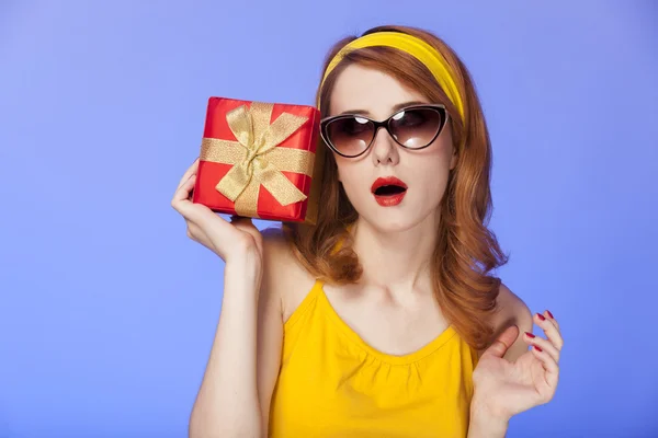 Amerikanische rothaarige Mädchen in Sonnenbrille mit Geschenk. — Stockfoto