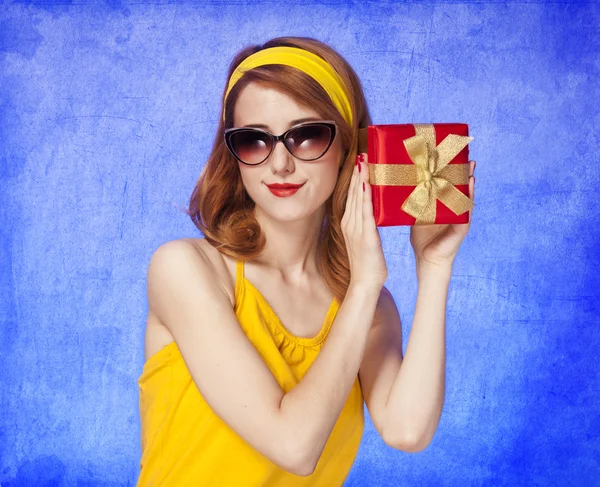 Amerikanska rödhårig flicka i solglasögon med gåva. — Stockfoto
