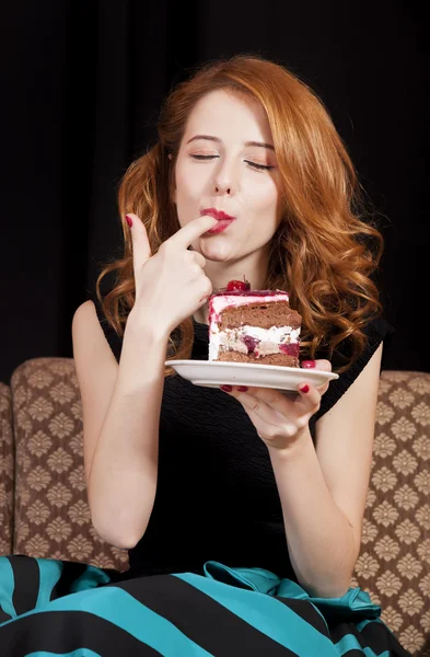 Roodharige meisje in het geheim eten taart. — Stockfoto