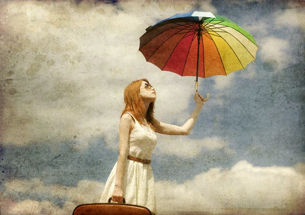 Hermosa chica pelirroja con paraguas y maleta al aire libre . —  Fotos de Stock