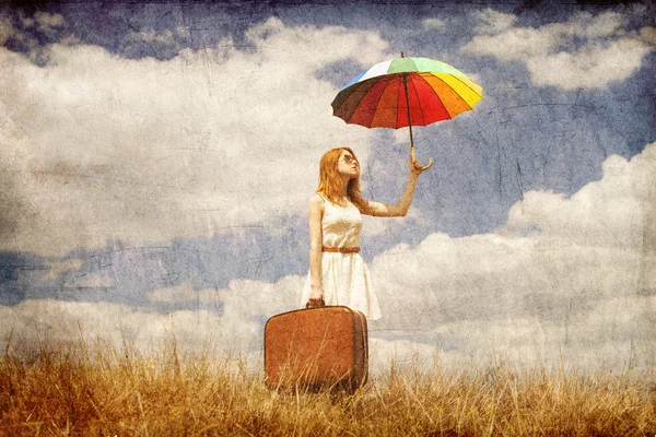 Όμορφη κοκκινομάλλα κοπέλα με ομπρέλα και βαλίτσα σε εξωτερικούς χώρους. — Φωτογραφία Αρχείου