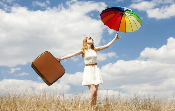 Vacker rödhårig tjej med paraply och resväska på utomhus. — Stockfoto