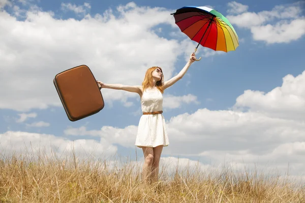Beautiful redhead girl with umbrella and suitcase at outdoor. — Stock Photo, Image