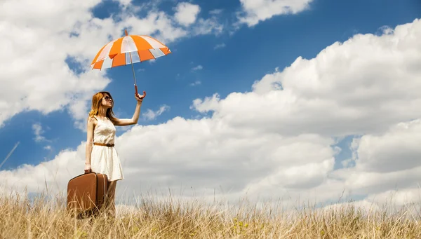 Vacker rödhårig tjej med paraply och resväska på utomhus. — Stockfoto
