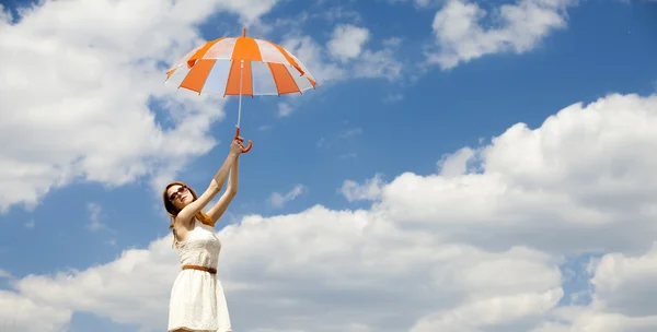 Flicka med paraply på himmel bakgrund. — Stockfoto