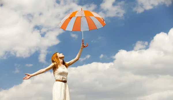Menina com guarda-chuva no fundo do céu . — Fotografia de Stock