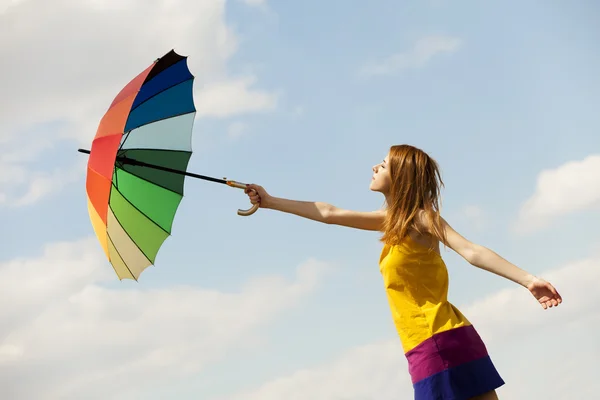 Flicka med paraply på himmel bakgrund. — Stockfoto