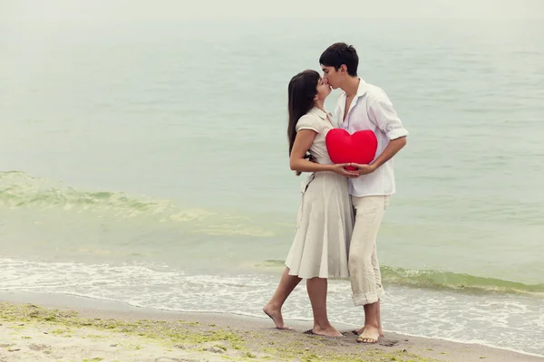 Vértes portréja boldog pár a strandon, a szív. — Stock Fotó