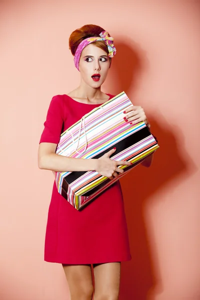 ピンクの背景でボックスのショッピング スタイルの赤毛の女の子. — ストック写真