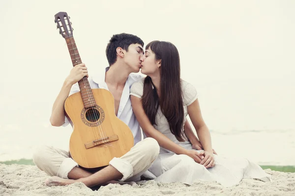 Пара цілується на пляжі і гітарі . — стокове фото