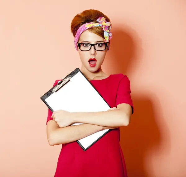 Stile rossa ragazza in occhiali e bordo su sfondo rosa . — Foto Stock