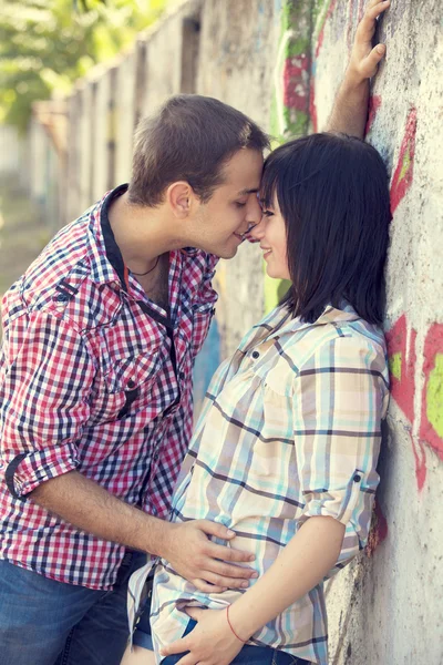 Νεαρό ζευγάρι φιλιά κοντά γκράφιτι φόντο. — Φωτογραφία Αρχείου