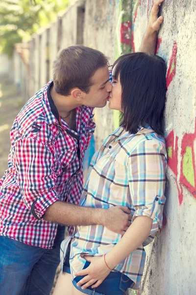 Young couple kissing near graffiti background. — Stock Photo, Image