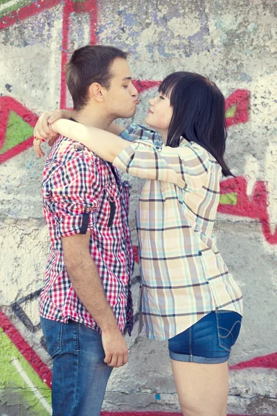Jong koppel kussen in de buurt van graffiti achtergrond. — Stockfoto
