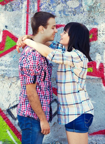 Stijl tiener paar in de buurt van graffiti achtergrond. — Stockfoto