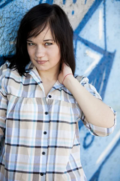 Stijl tiener meisje in de buurt van graffiti achtergrond. — Stockfoto