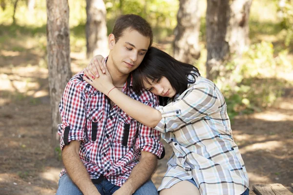 Грустная молодая пара в зеленом парке . — стоковое фото