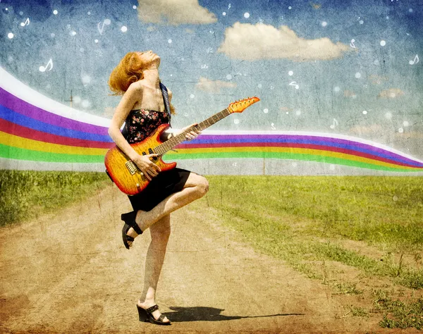 Ragazza rock con chitarra in campagna e arcobaleno — Foto Stock