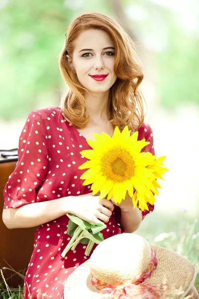 Rotschopf Mädchen mit Sonnenblume im Freien. — Stockfoto