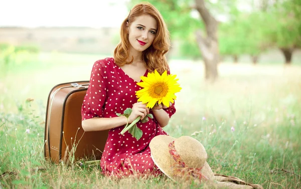 Rotschopf Mädchen mit Sonnenblume im Freien. — Stockfoto