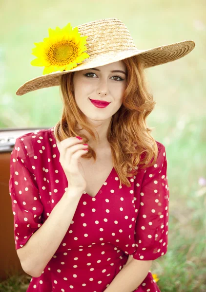 Roodharige meisje met zonnebloem op buiten. — Stockfoto
