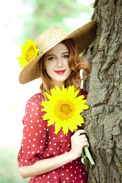 Rusovláska dívka s slunečnice na venkovní. — Stock fotografie