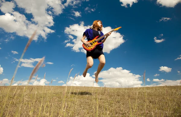 야외에서 기타와 함께 점프 하는 빨강 머리 소녀. — 스톡 사진