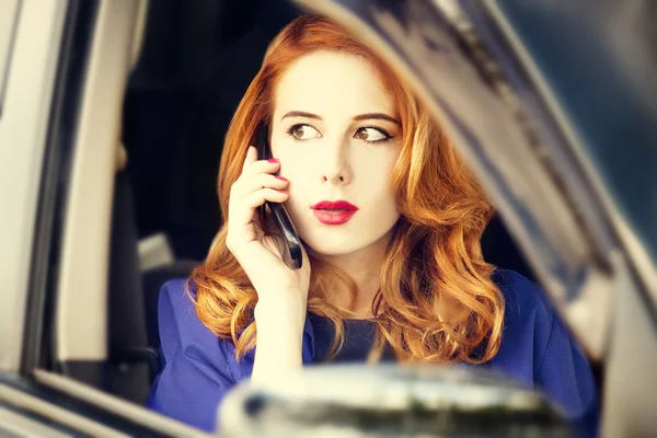 Mooie roodharige zakenvrouw bellen via de telefoon in de auto. — Stockfoto