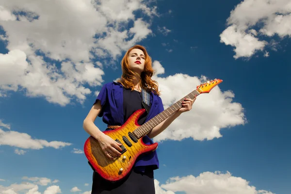 Rödhårig tjej med gitarr på utomhus. — Stockfoto