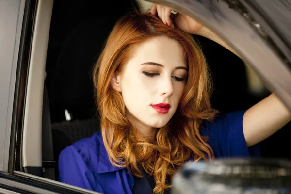 stock image Beautiful redhead woman in the car.