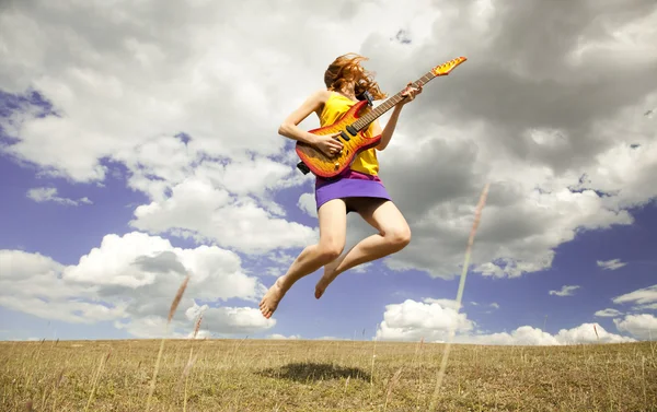Redhead girl jumping with guitar at outdoor. — Stock Photo, Image