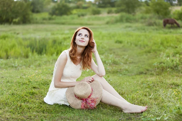 红发女孩在村户外的绿草. — 图库照片