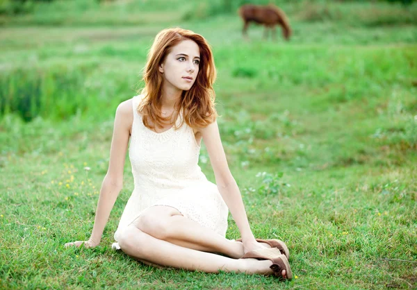 红发女孩在村户外的绿草. — 图库照片