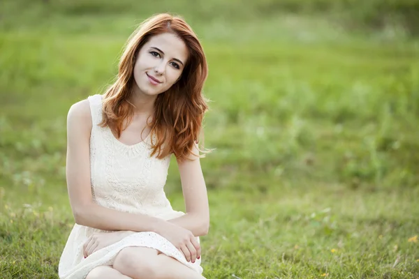 Pelirroja chica en verde hierba en pueblo al aire libre . — Foto de Stock