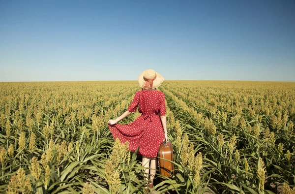 Руда дівчина з валізою на кукурудзяному полі . — стокове фото