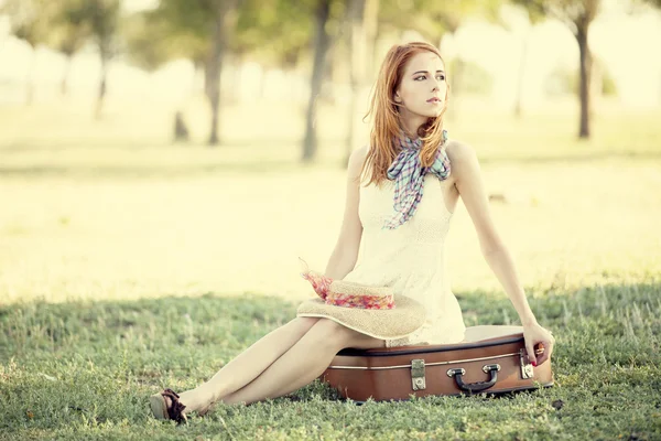 屋外での袋に座っている赤毛の女の子. — ストック写真