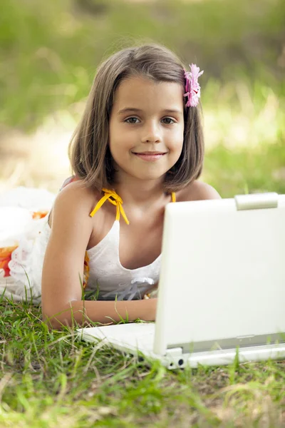 Enfant avec ordinateur portable au parc . — Photo