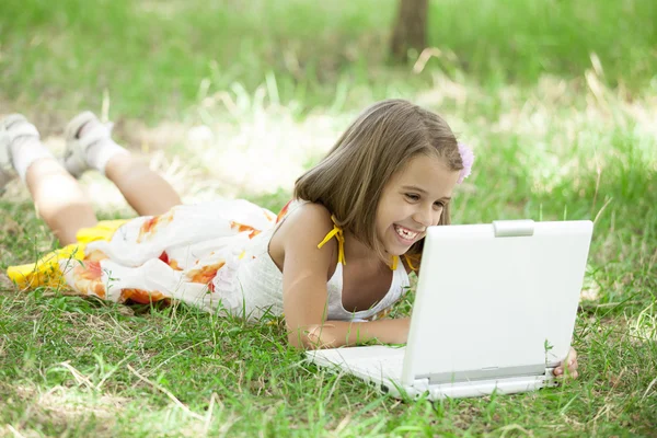 Child with laptop at park. — Stock Photo, Image