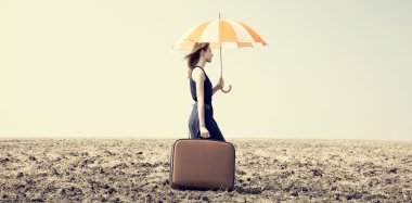 Redhead girl with umbrella at windy field. clipart