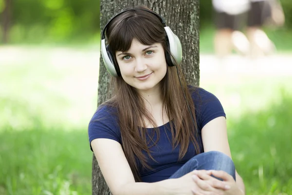 Młoda dziewczyna moda ze słuchawkami w zielonej trawie wiosna. — Zdjęcie stockowe